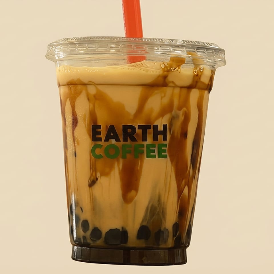 Earth Coffee iced caramel coffee drink with tapioca pearls in a clear branded cup and red straw.